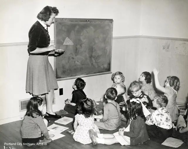 Students gathered around a large sheet of paper writing together during a workshop